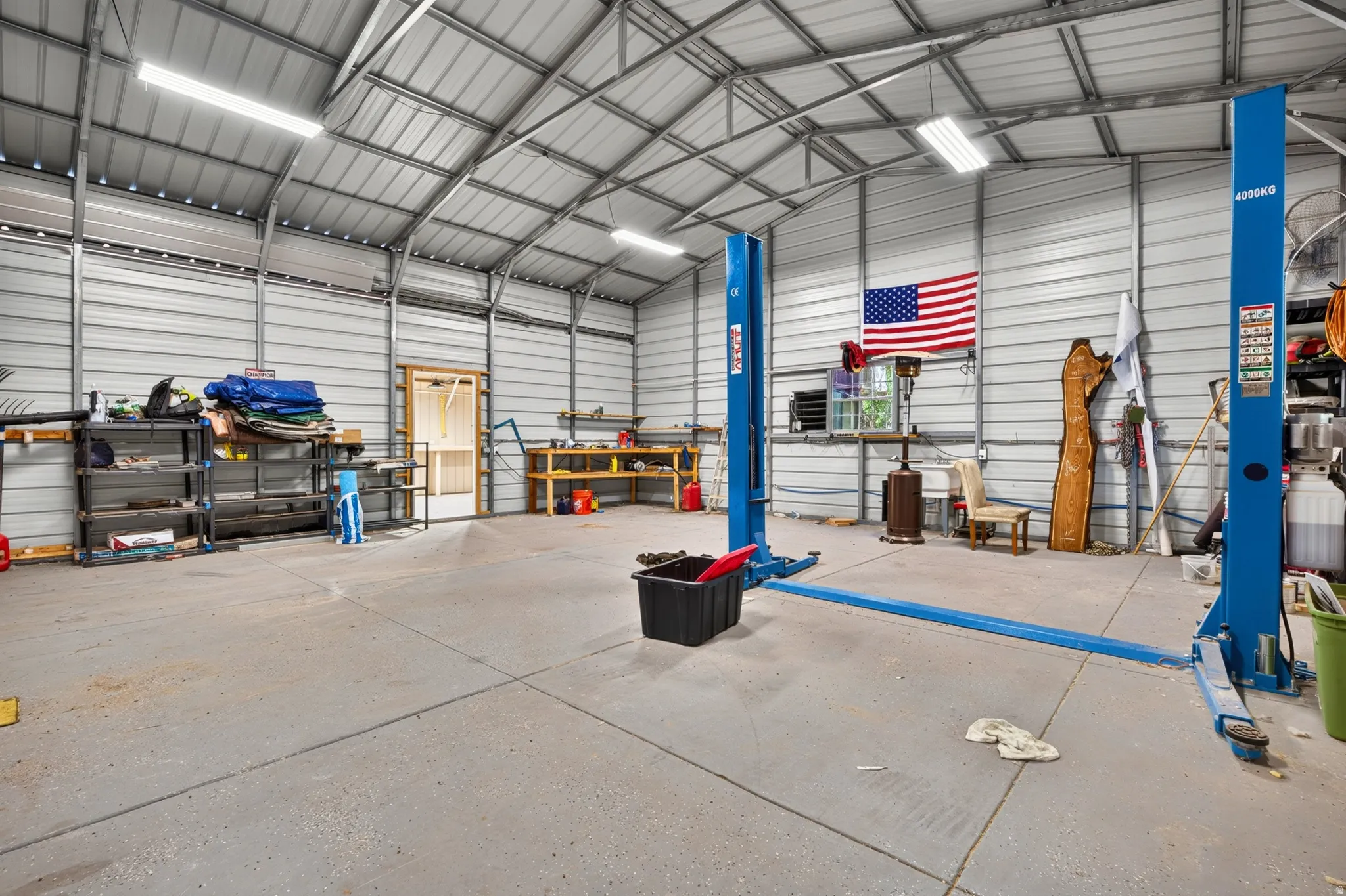 Spacious metal-frame building featuring concrete flooring, corrugated metal walls and ceiling, and exposed structural beams