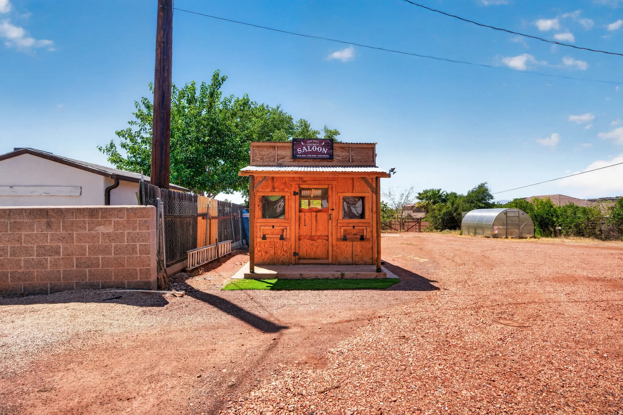 Freestanding wood-sided structure with a corrugated metal roof and a "Saloon" facade