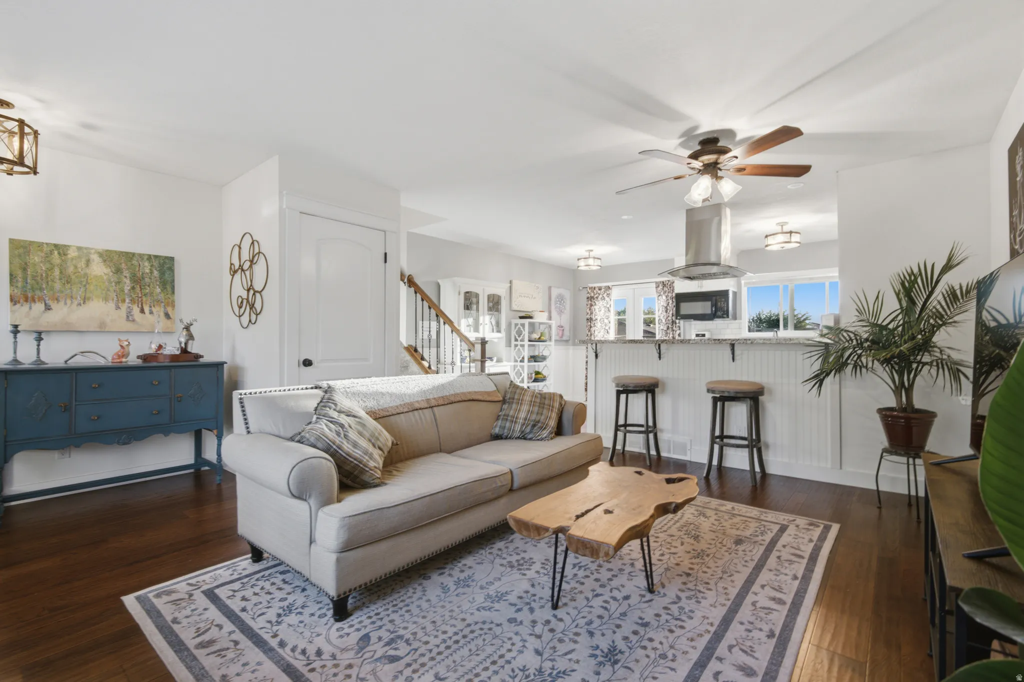 Hardwood-finish flooring, recessed lighting, ceiling fan, breakfast bar with pendant lighting, and stainless steel range hood