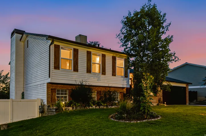 Split-level exterior featuring white siding and brick accents