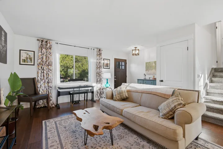 Hardwood-finish flooring, white walls, and a multi-pane entry door