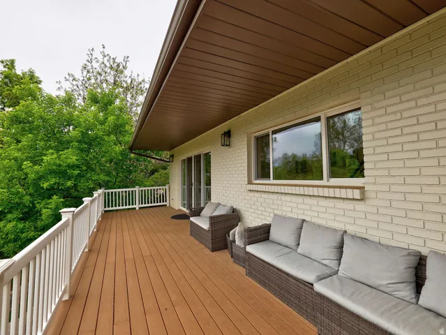 Expansive outdoor deck featuring wood-finish flooring and white perimeter railing