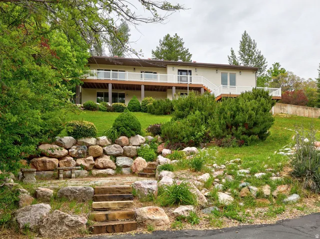 Terraced landscaping featuring a stone retaining wall, stone steps, and mature plantings
