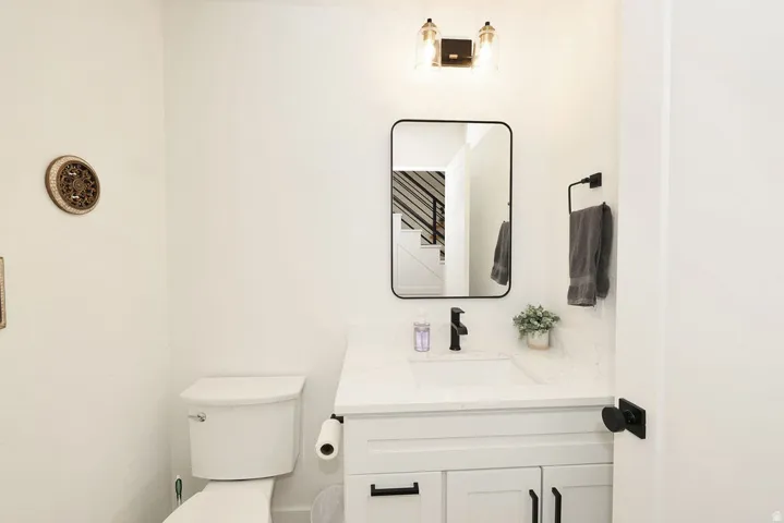 White vanity with shaker-style cabinetry, a white countertop, and a rectangular undermount sink