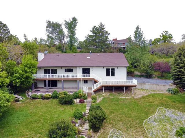 Split-level residence featuring a white exterior and a brown shingle roof