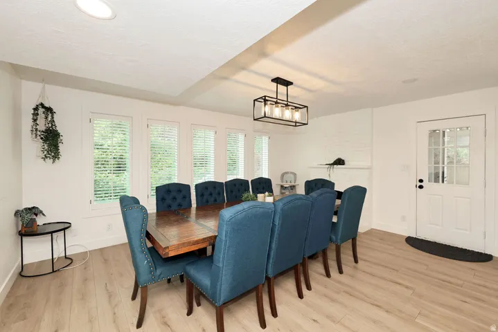 Dining area featuring wood-finish flooring, recessed lighting, and a linear chandelier