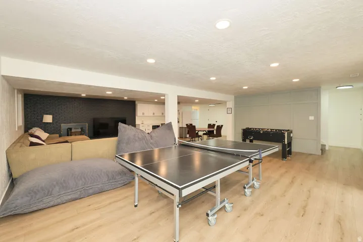 Open recreational space featuring wood-finish flooring and recessed lighting