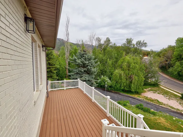 Expansive outdoor deck featuring wood-finish flooring and white railings