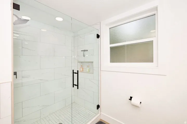 Contemporary shower enclosure featuring clear glass panels with matte black hardware