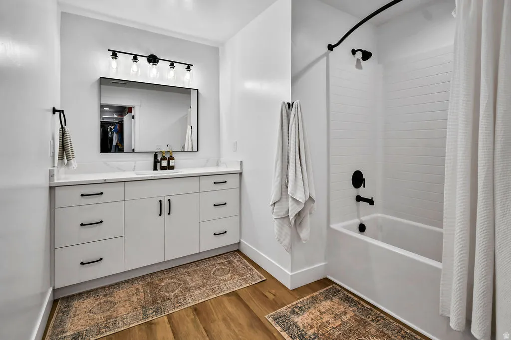 Bathroom featuring a white vanity with integrated sink, quartz-finish countertop, and matte black hardware
