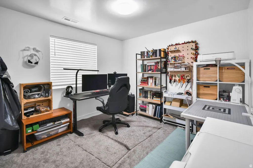 Carpeted room featuring a window with horizontal blinds, built-in overhead lighting, and a ceiling vent
