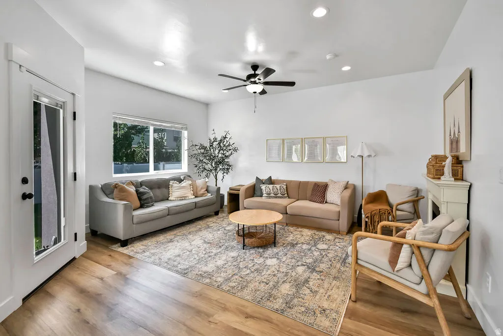 Living area with wood-finish flooring, white walls, and recessed lighting