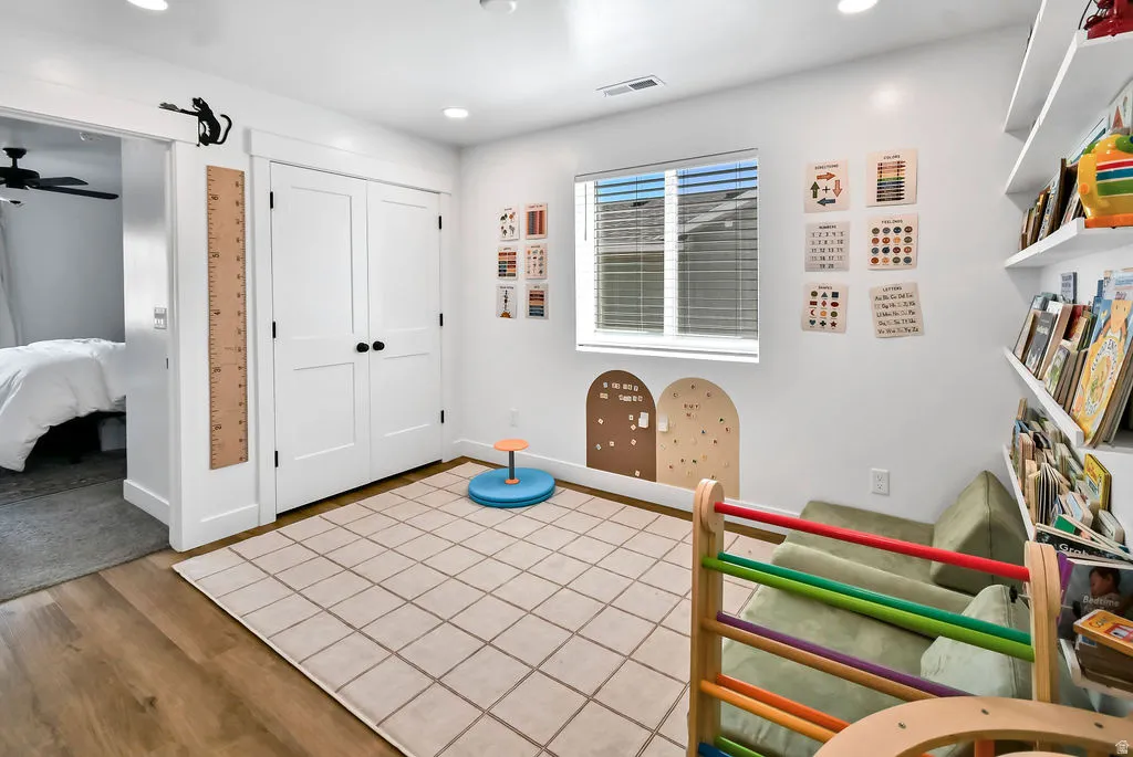 Room featuring wood-finish flooring, recessed lighting, and a window with blinds