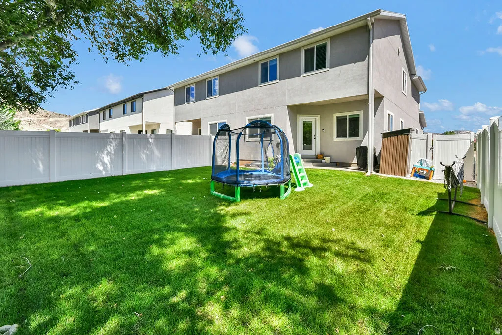 Expansive backyard featuring a manicured lawn, full fencing, and a private patio area