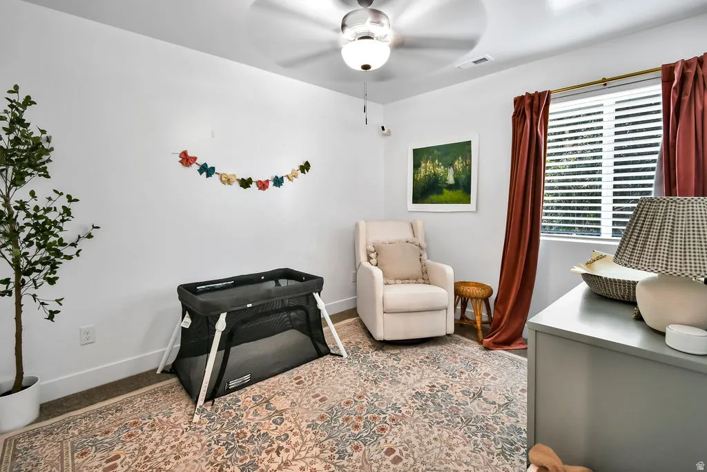 Room with white walls and a ceiling fan with integrated lighting