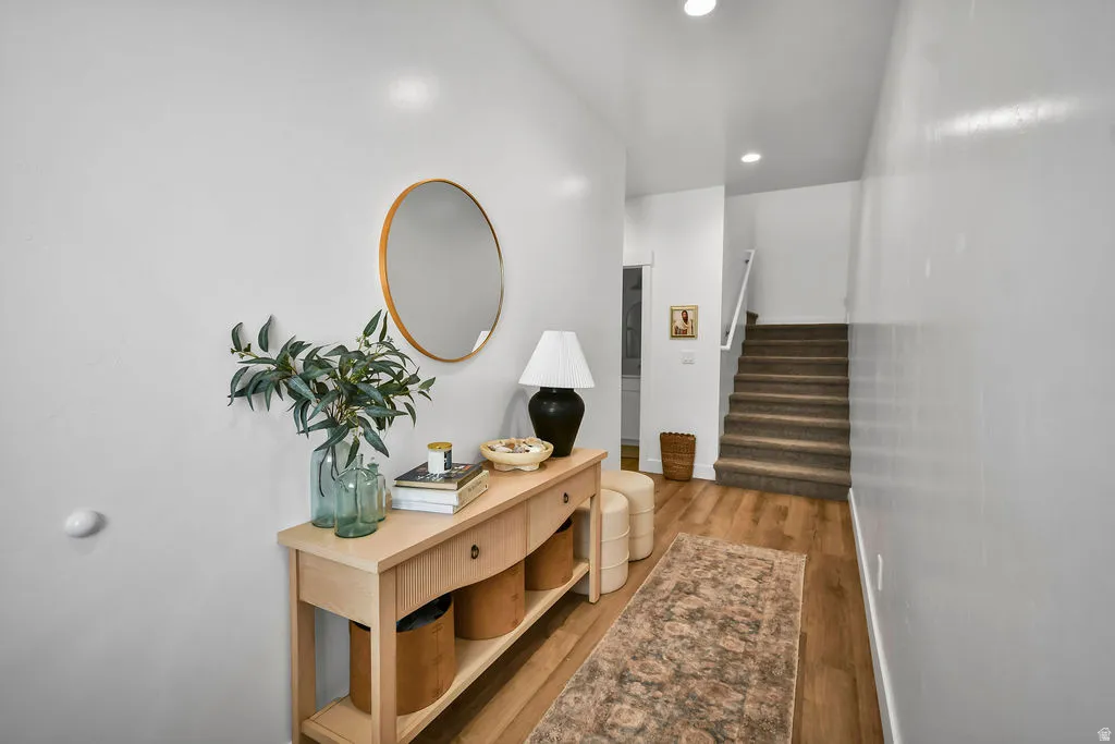 Entryway featuring wood-finish flooring, white walls, and recessed lighting