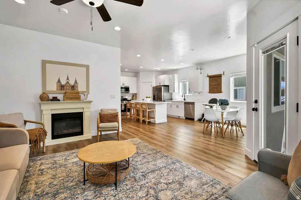 Open-concept living space with wood-finish flooring, recessed lighting, and a ceiling fan
