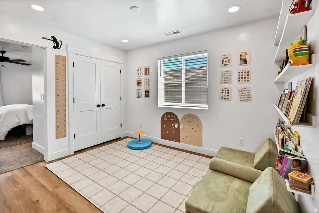 Recessed lighting illuminates this bright room featuring wood-finish flooring