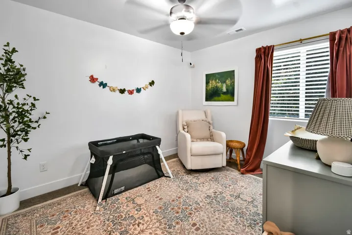 Room with white walls and a ceiling fan with integrated lighting