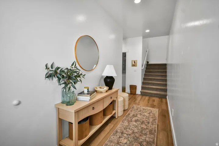 Entryway featuring wood-finish flooring, white walls, and recessed lighting