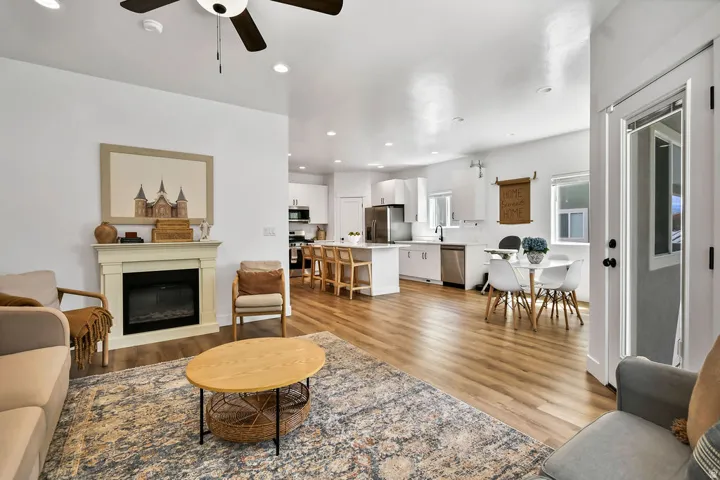 Open-concept living space with wood-finish flooring, recessed lighting, and a ceiling fan