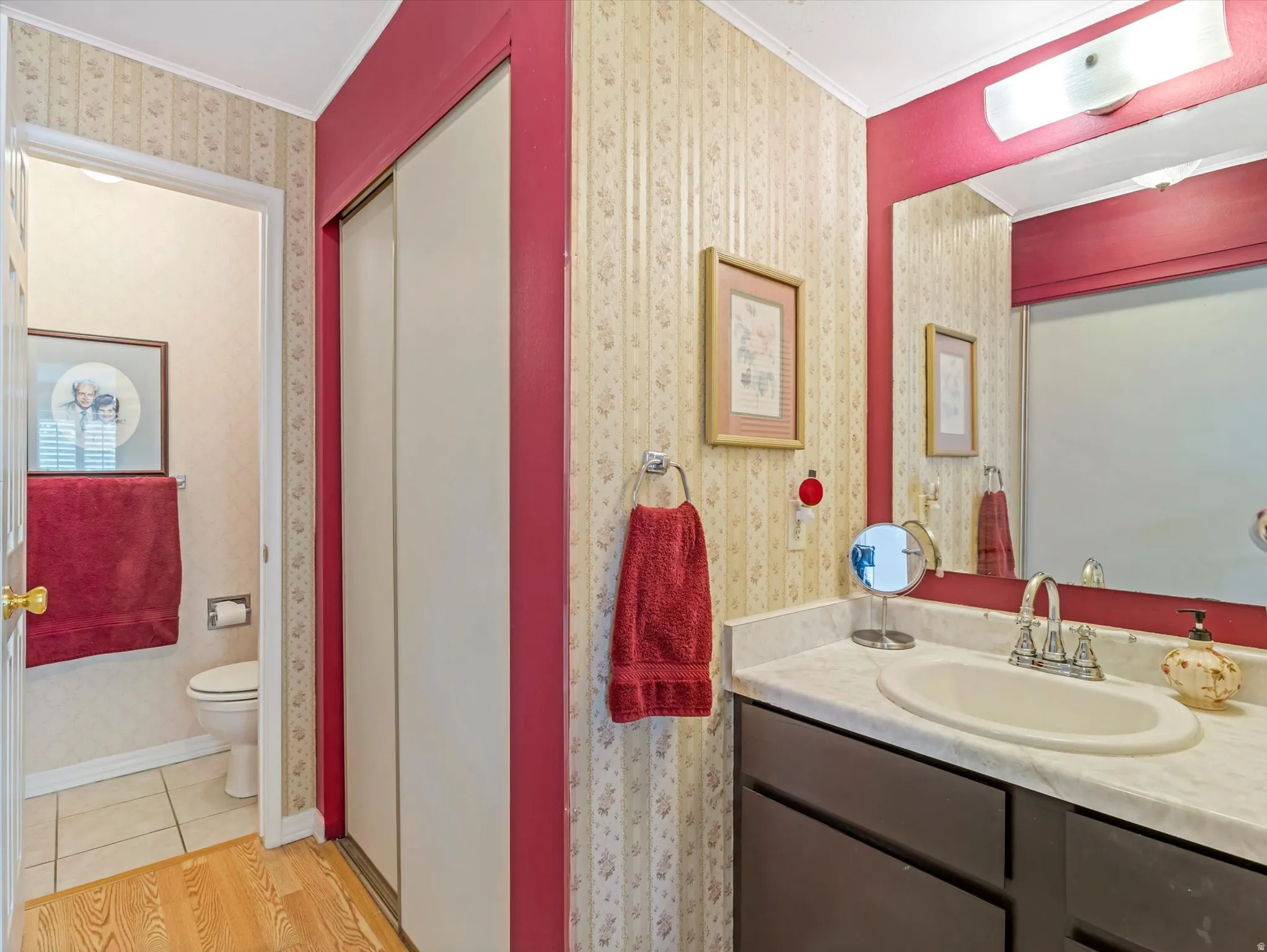 Vanity featuring a white oval sink set in a light-toned countertop, with a dark wood-finish cabinet below
