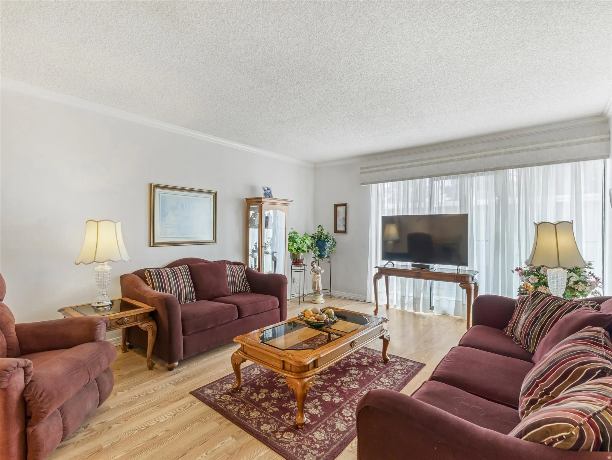 Light wood-finish flooring complements white walls and crown molding