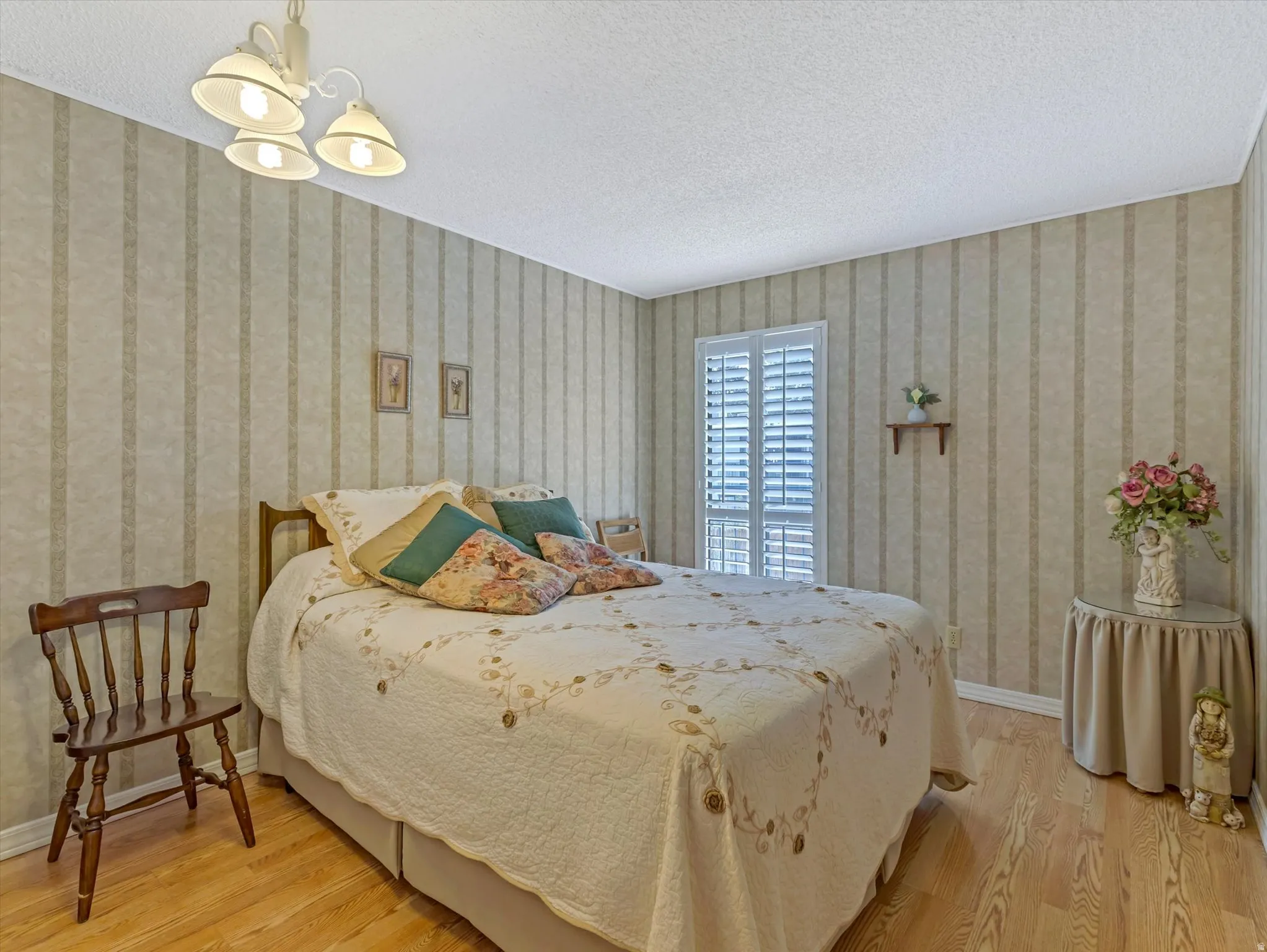 Light wood-finish flooring complements the room with striped wallpaper