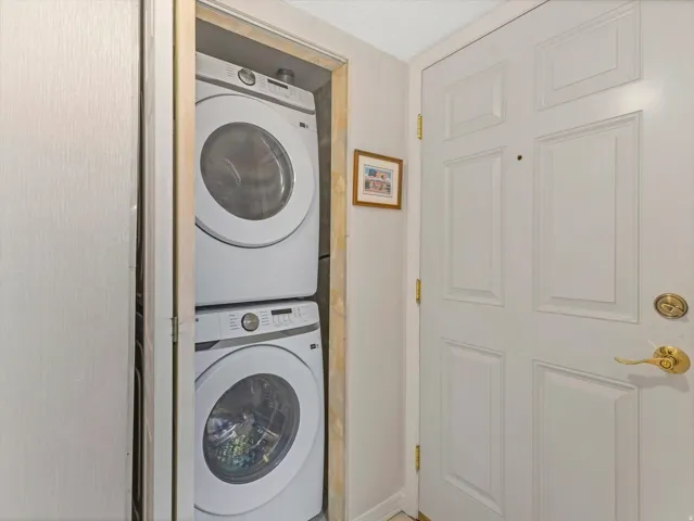 Dedicated laundry closet featuring a stacked washer and dryer