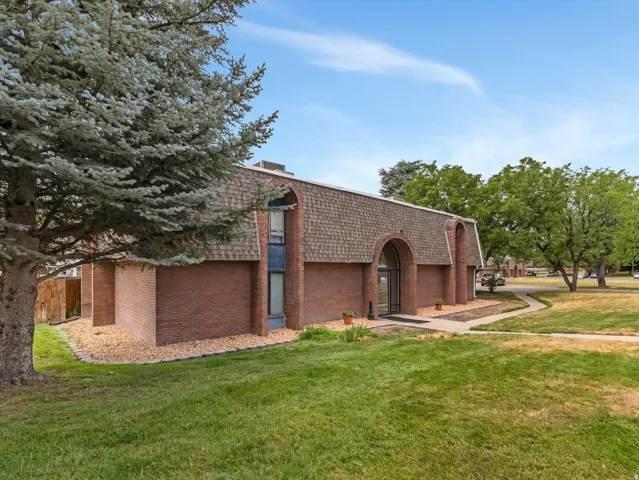 Brick exterior with a prominent arched entry and a shingled gambrel roofline