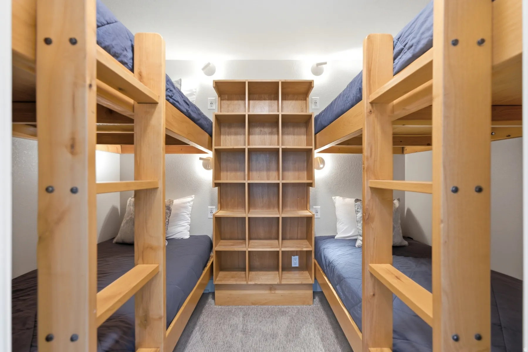 Built-in bunk beds with natural wood frames, integrated ladders, and accent lighting
