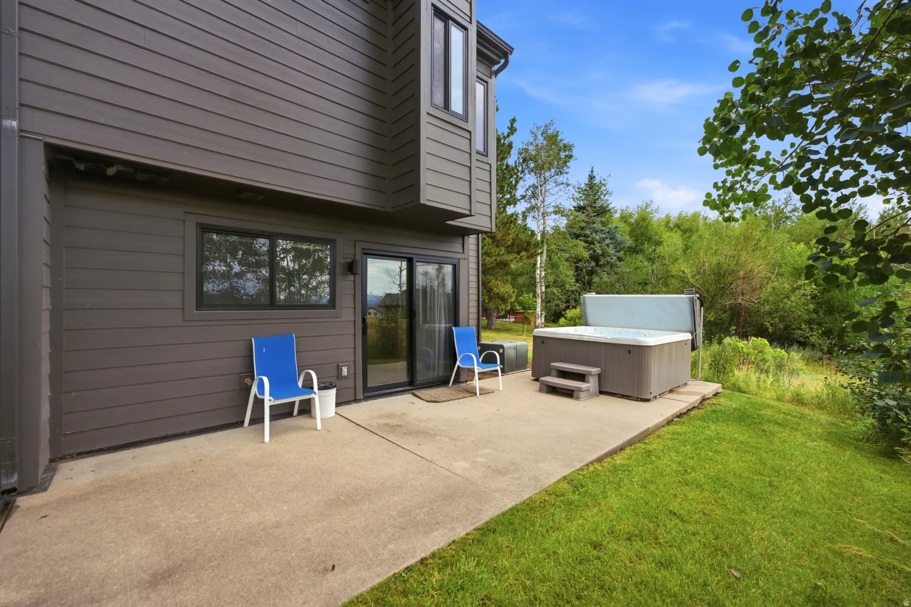 Exterior patio featuring a built-in spa, concrete surfacing, and direct access to the interior via sliding glass doors