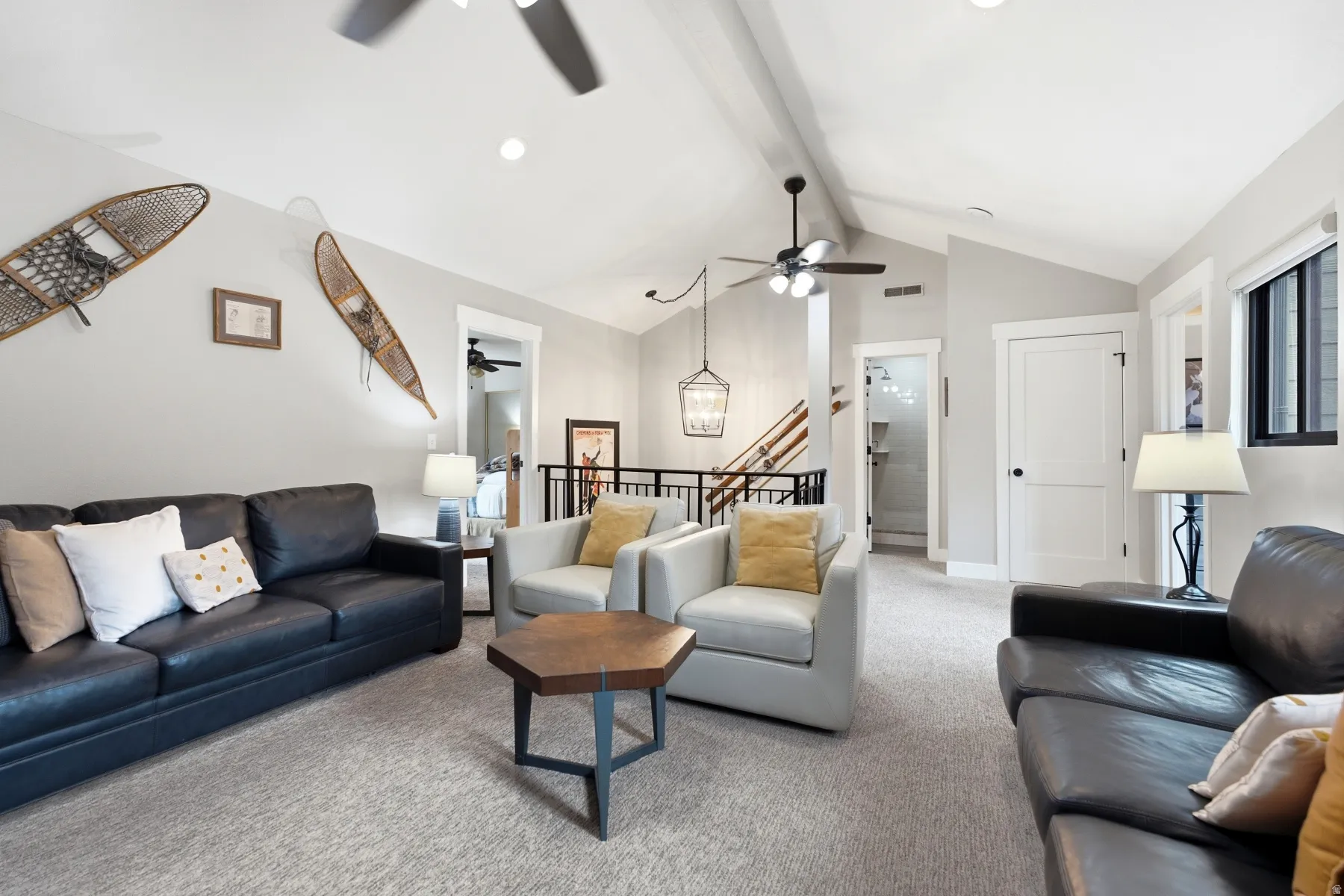 Spacious living area featuring vaulted ceilings, recessed lighting, and soft gray carpeting