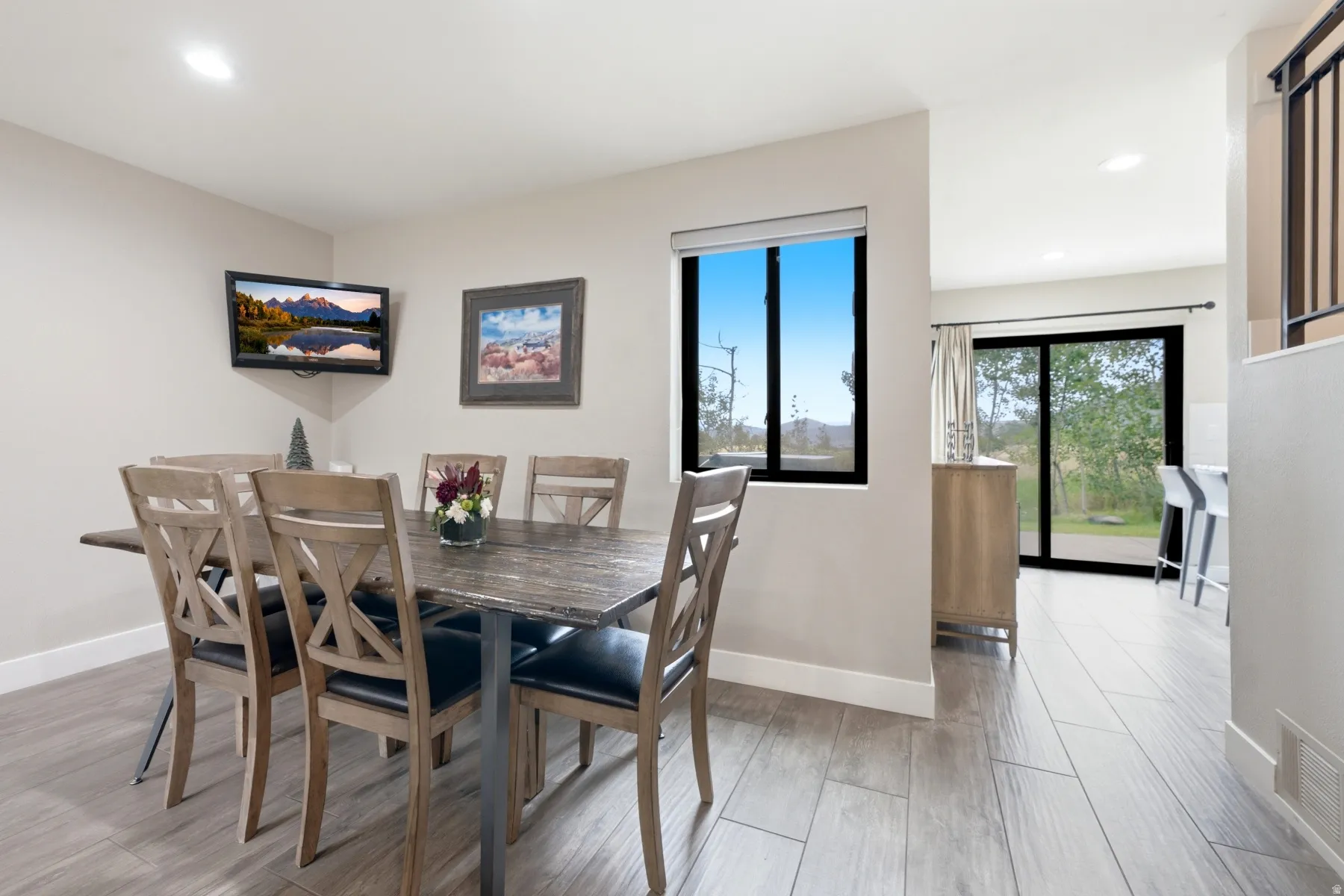 Dining area featuring wood-finish flooring, recessed lighting, a single window, and a sliding glass door