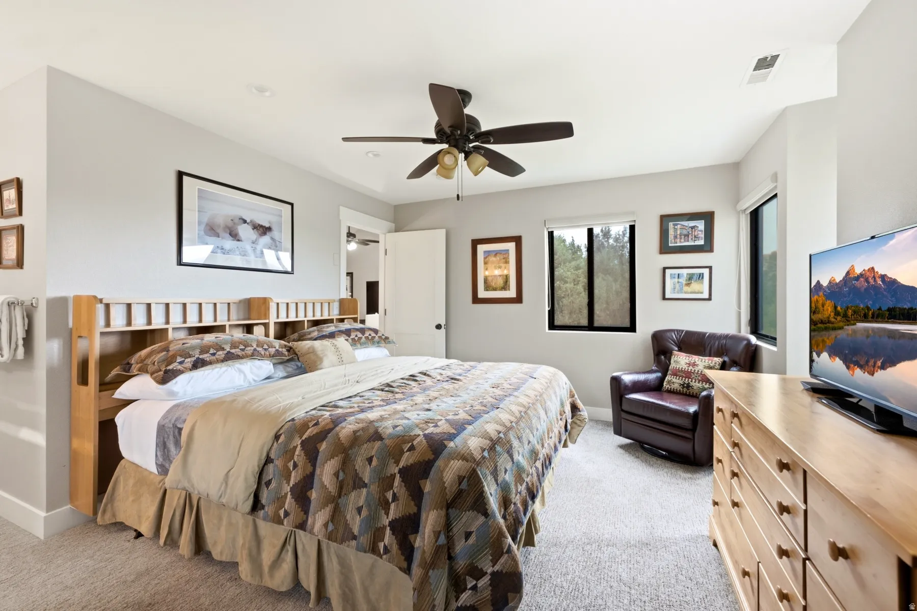 Carpeted room featuring a ceiling fan, recessed lighting, and multiple windows