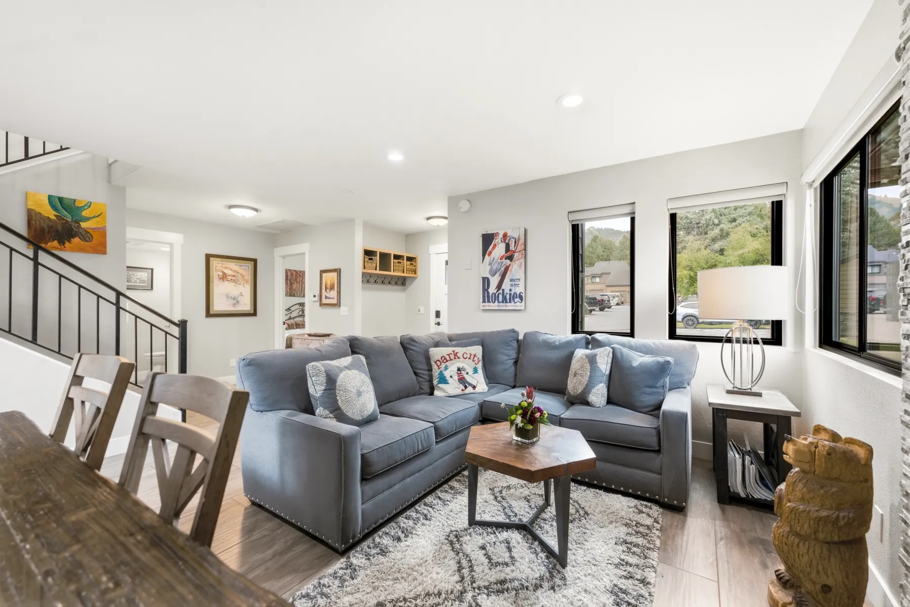 Open-concept living space featuring wood-finish flooring, recessed lighting, and large windows with black frames