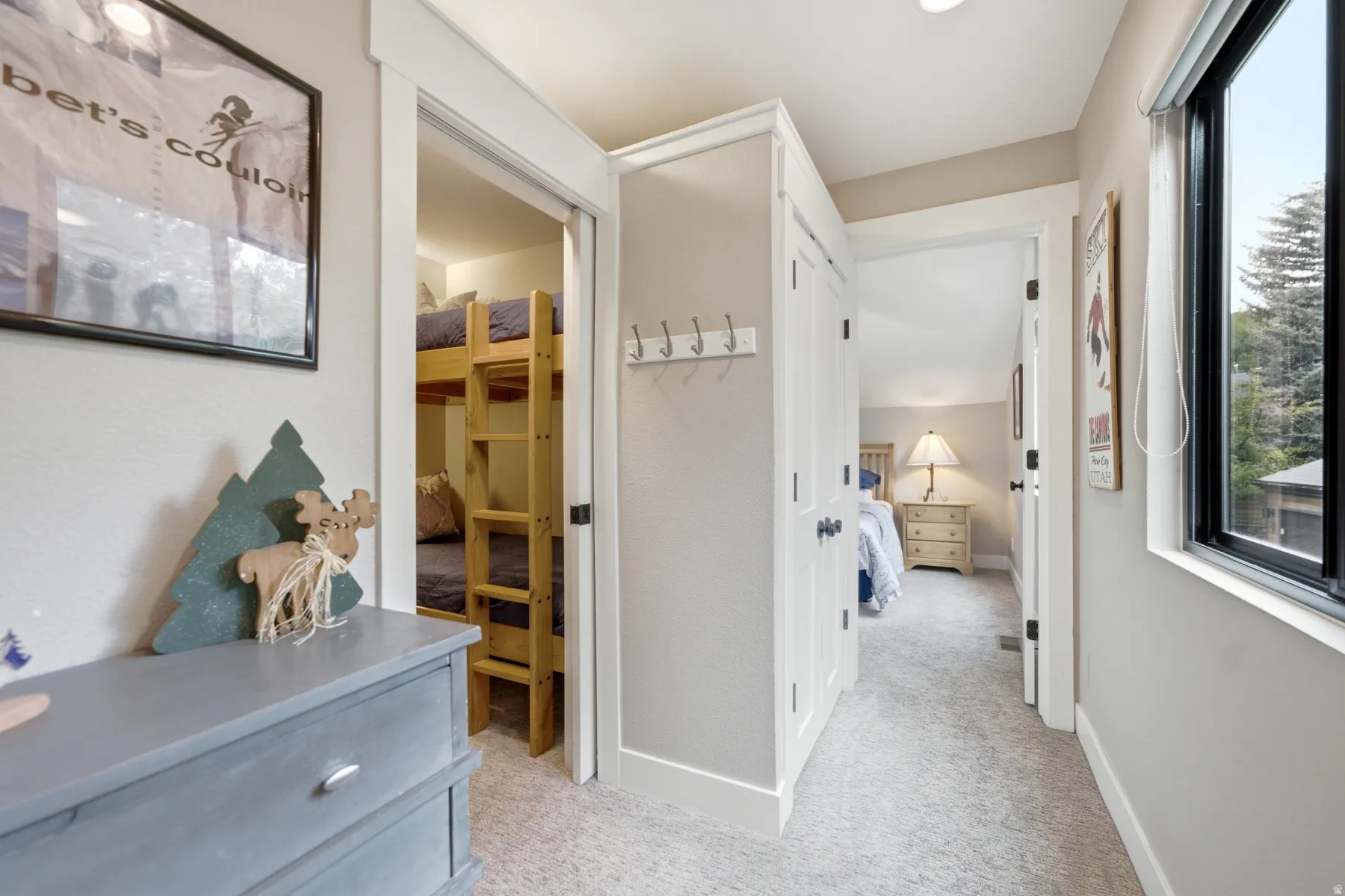 Hallway with neutral carpeting, white trim, and light gray walls