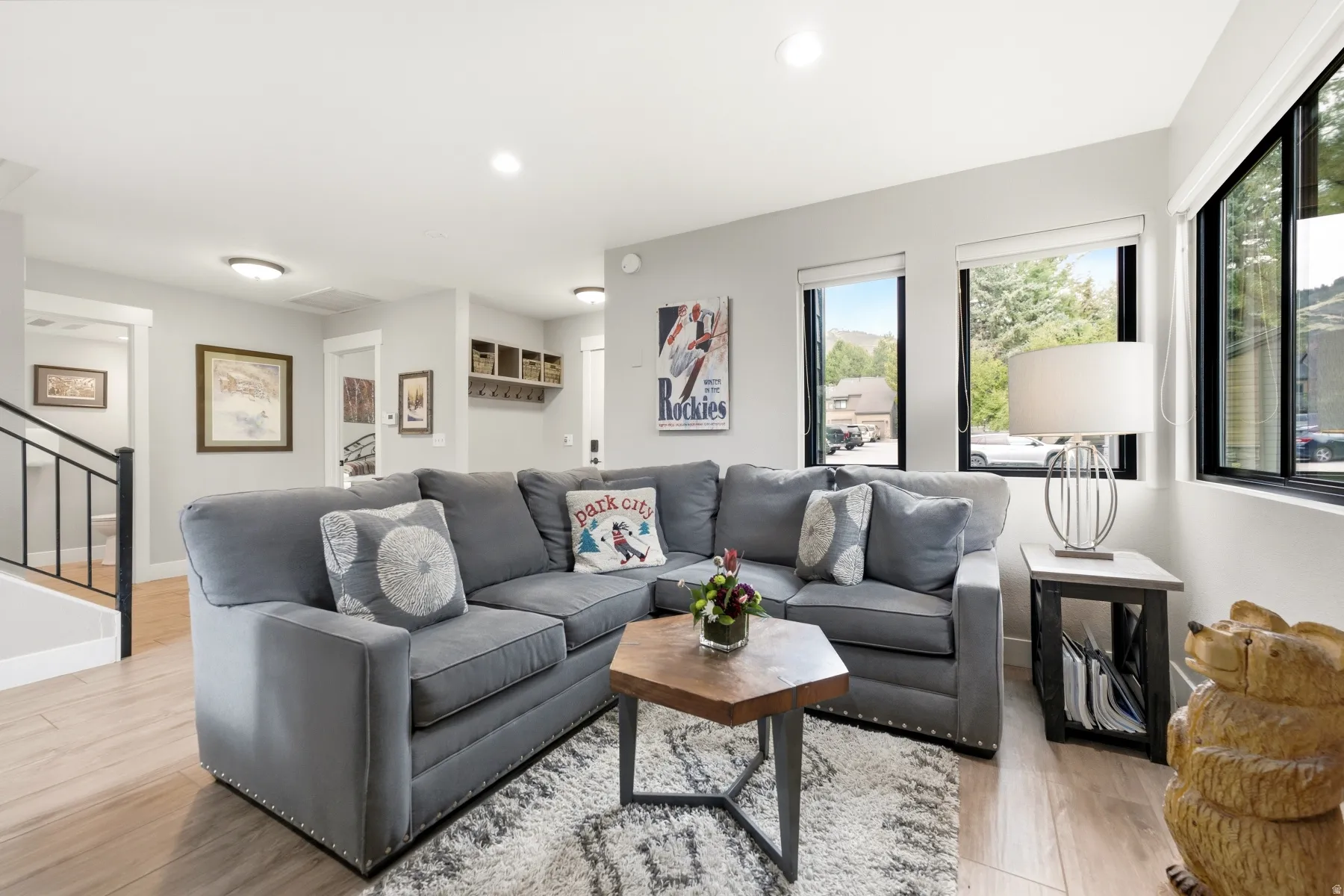 Bright living area featuring wood-finish flooring, recessed lighting, and multiple windows with dark frames