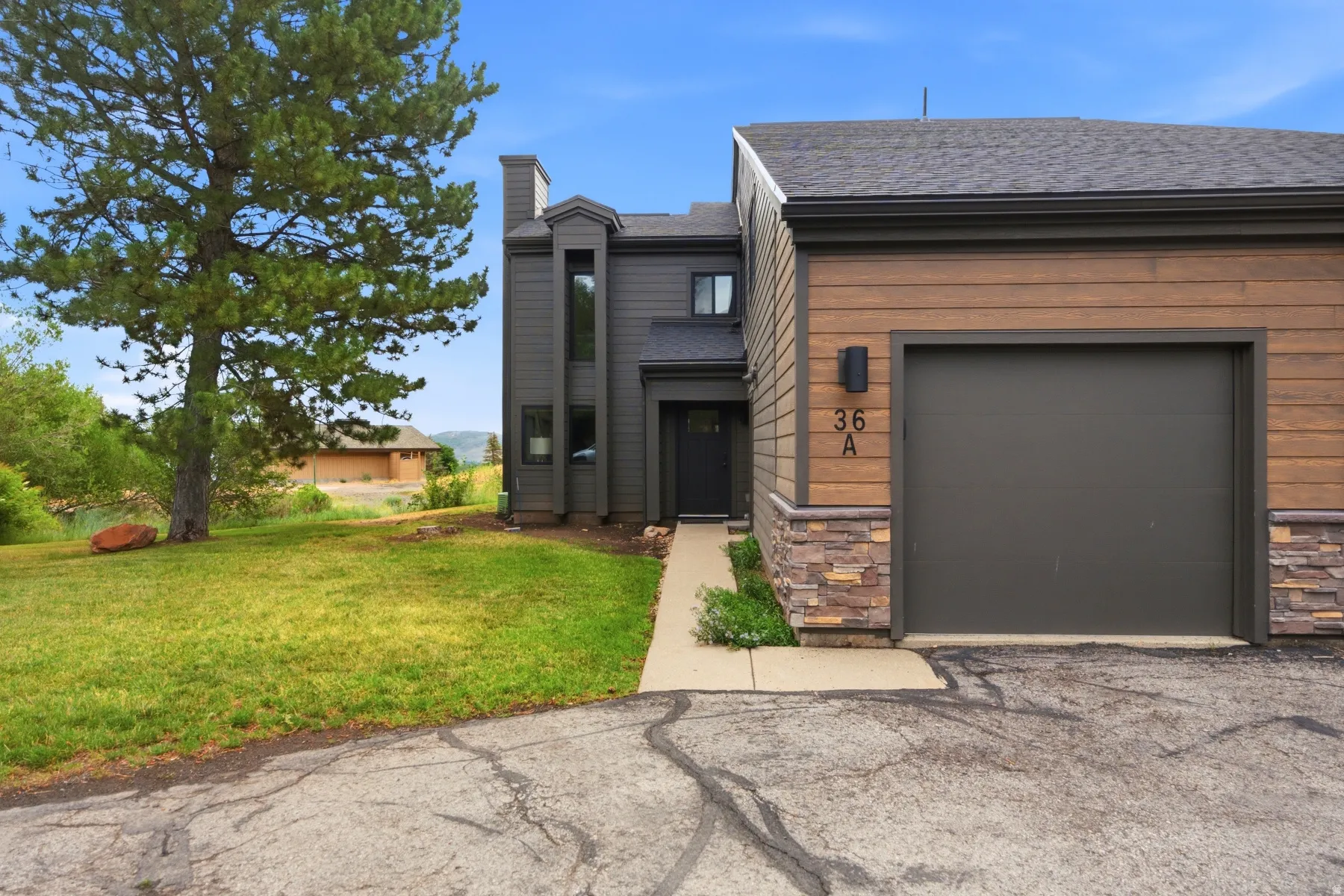 Modern exterior featuring varied siding materials including wood-look panels and stone accents
