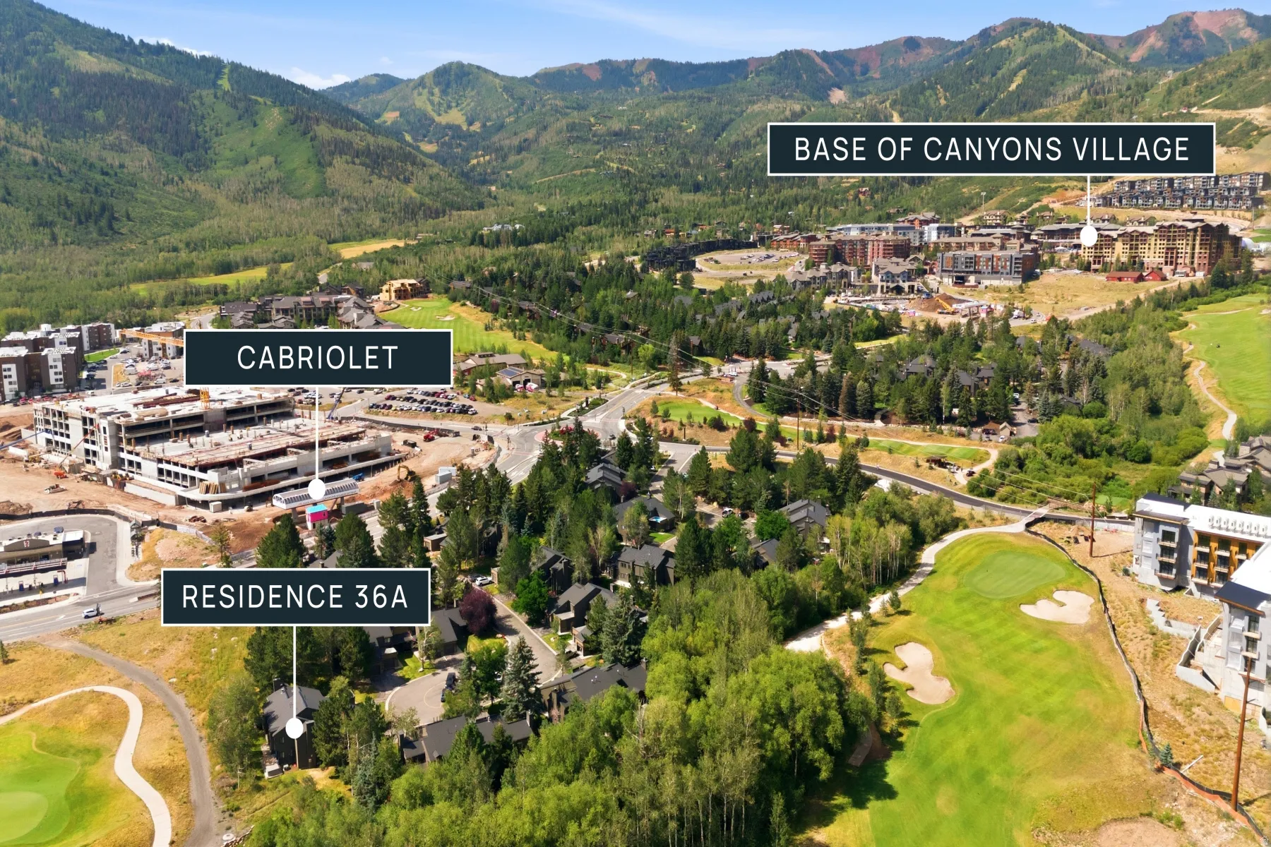 Aerial perspective featuring a mountainous landscape, verdant trees, and developed properties