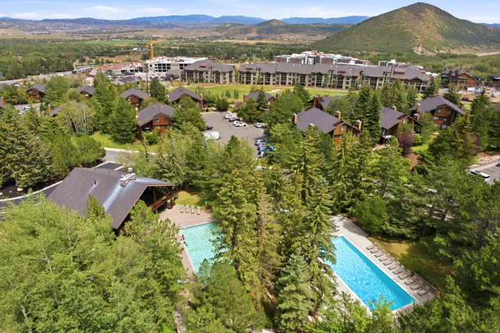 Aerial perspective showcasing multiple properties amidst mature trees
