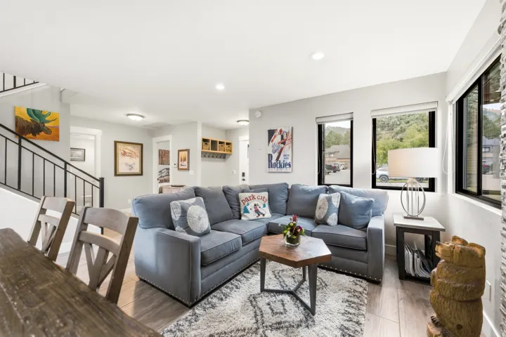 Open-concept living space featuring wood-finish flooring, recessed lighting, and large windows with black frames