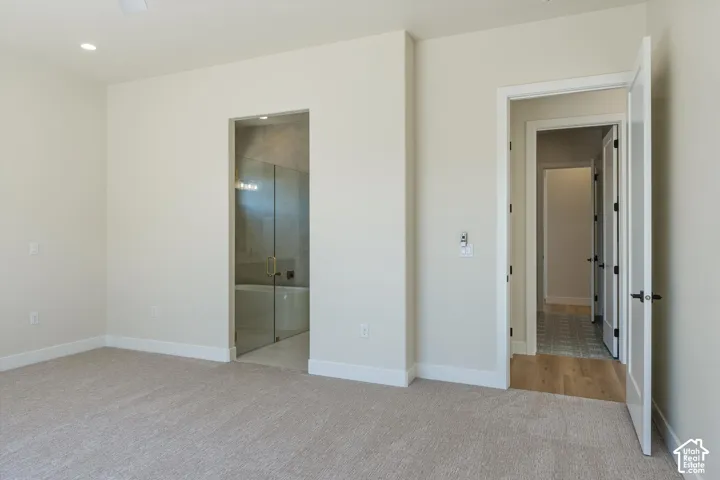 Plush carpet flooring, recessed lighting, and a neutral wall palette