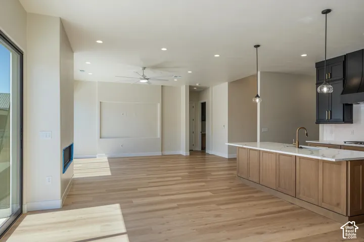 Open-concept living space with wood-finish flooring, recessed lighting, and a ceiling fan