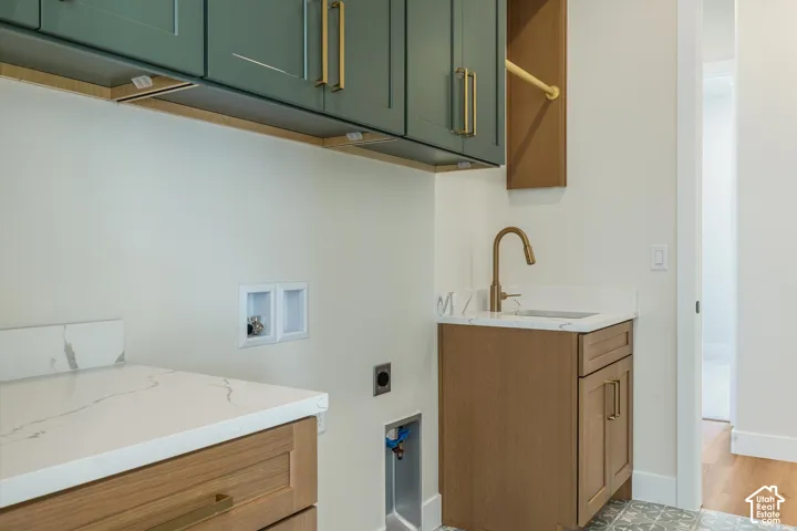 Green upper cabinetry with brass hardware