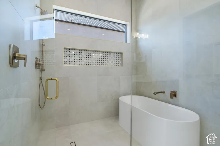 Glass-enclosed shower with a handheld showerhead and built-in niche