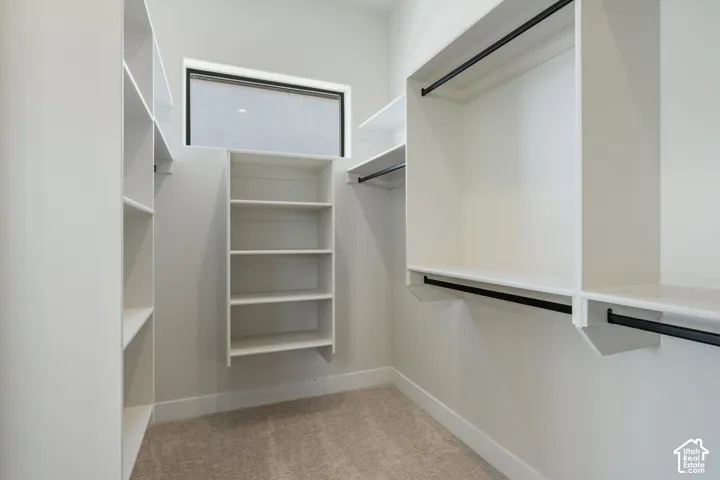 Built-in shelving, white cabinetry, integrated hanging rods, and a high horizontal window