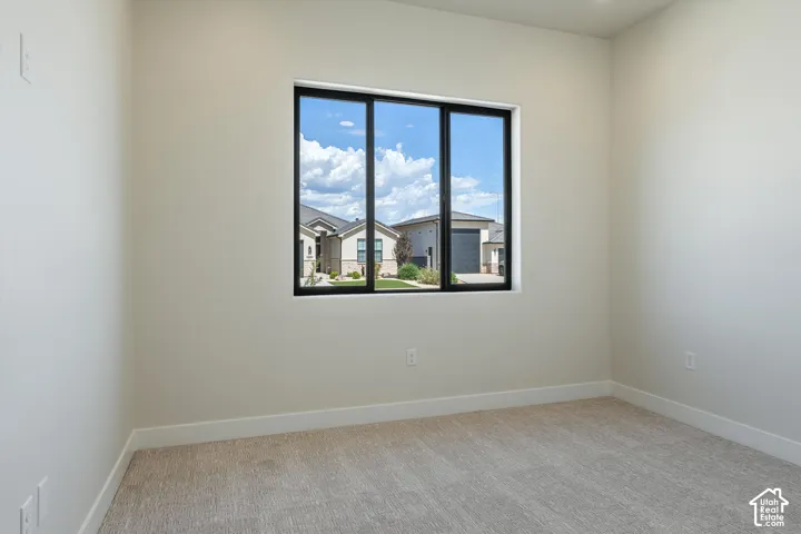 Wall-to-wall carpeting with light neutral walls, and a large window with black framing