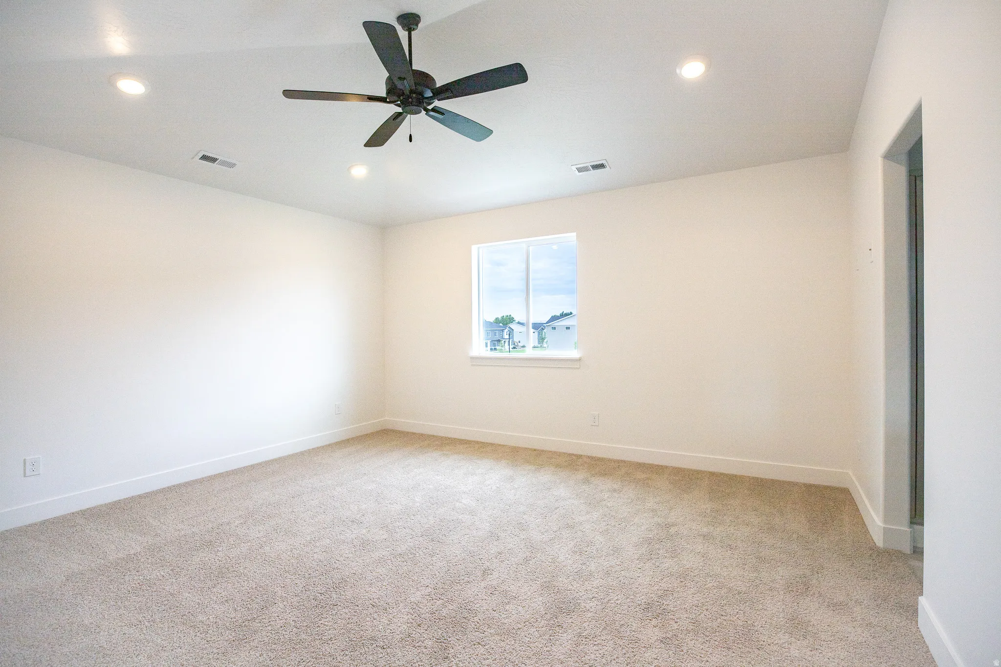 Primary bedroom with vaulted ceilings recessed lighting, and a ceiling fan
