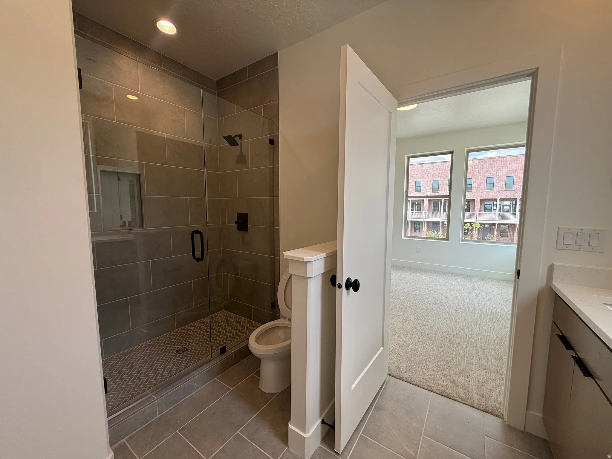 Walk-in shower with full glass enclosure and dark-finish hardware